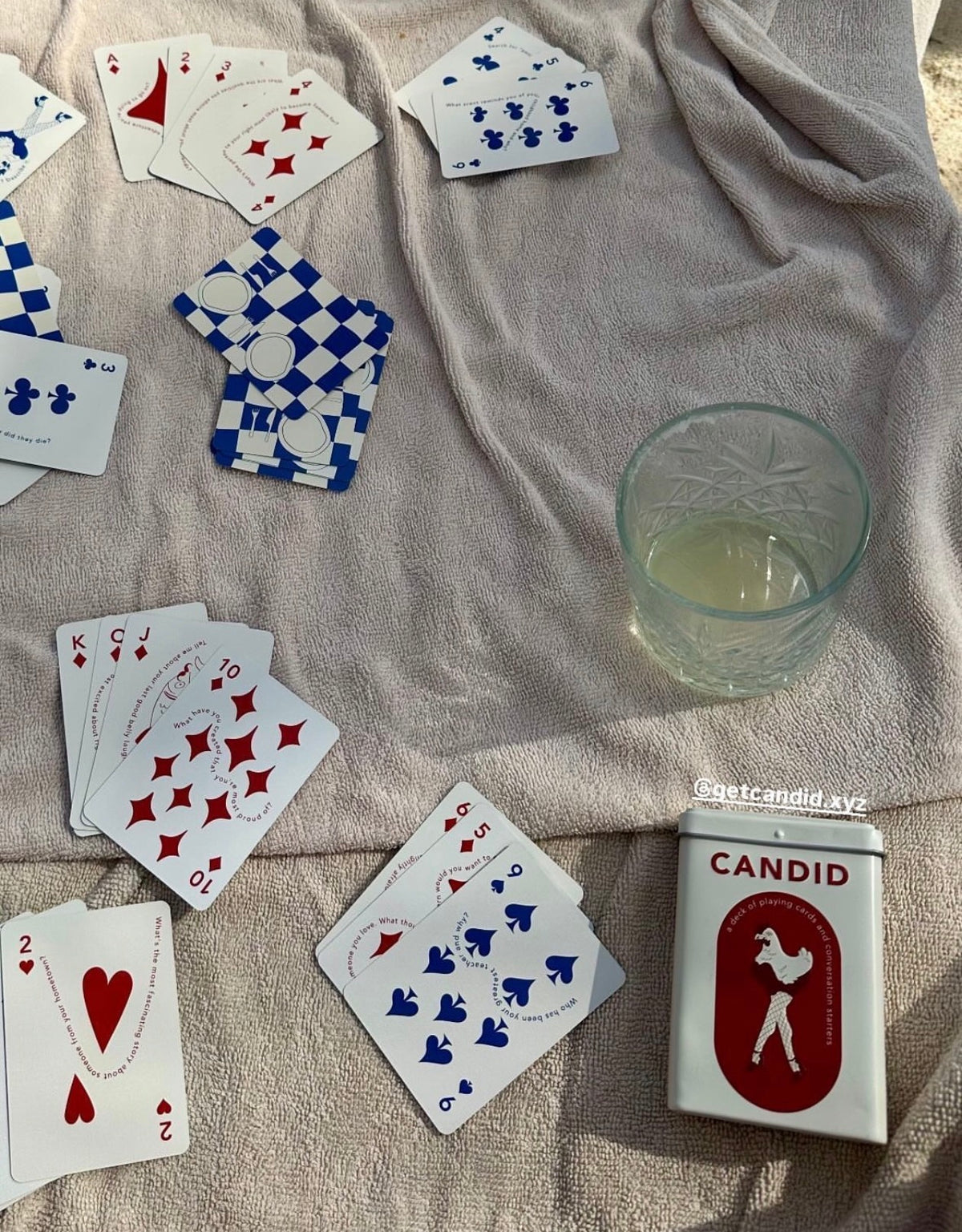 CANDID cards and tin on a blanket